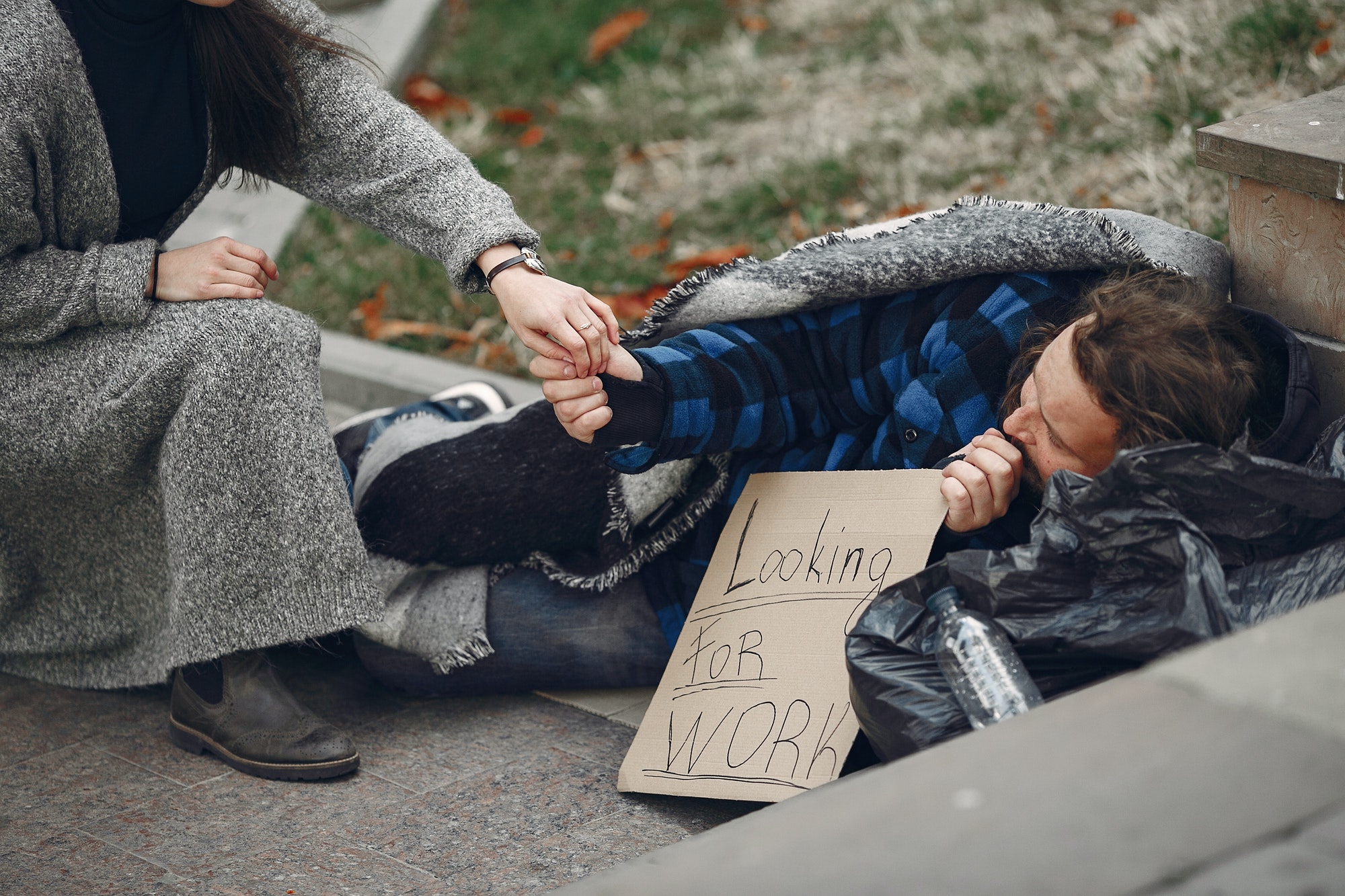 Homeless man in a durty clothes autumn city